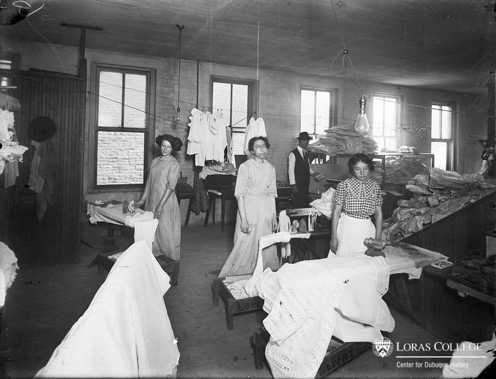 Based on her investigation of laundries in 1915, Iowa’s woman factory inspector reported that the constant standing and continual use of the arm, combined with the heat and steam, made hand ironing one of the heavy jobs of laundry work. In one Dubuque laundry, however, the female ironers earned only half as much as the male drivers who brought home $12/week. (Lorenz Laundry, 1912)
